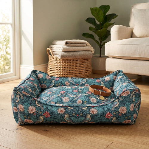 Floral bolster pet bed with teal-blue fabric, rounded sides and top cushion