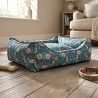 Floral bolster pet bed in teal-blue with curved bolster sides and stitched edge