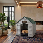 White plastic dog house with green roof and arched door; dog curled inside on rug