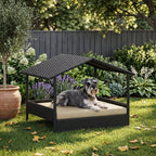 Elevated outdoor dog day bed with sun canopy, dark wicker texture and beige cushion; small dog resting