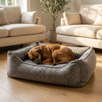 Gray corduroy orthopaedic pet bed with cushioned bolsters and textured fabric; brown dog lying