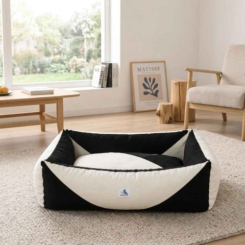 Orthopaedic dog bed with black sides and white pressure-relief bolster in a low oval shape