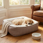 Taupe memory foam dog mattress bed with rounded bolsters, used on hardwood floor
